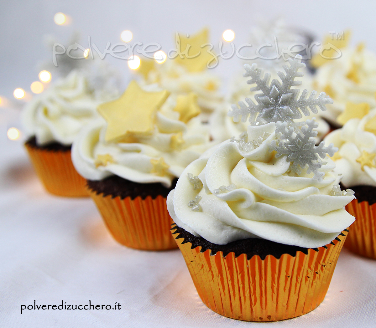 cupcake decorati con fiocchi di neve e stelle dorate per un compleanno in inverno
