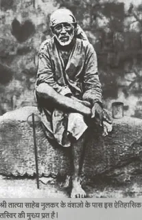 sai baba is sitting in his usual position on a stone