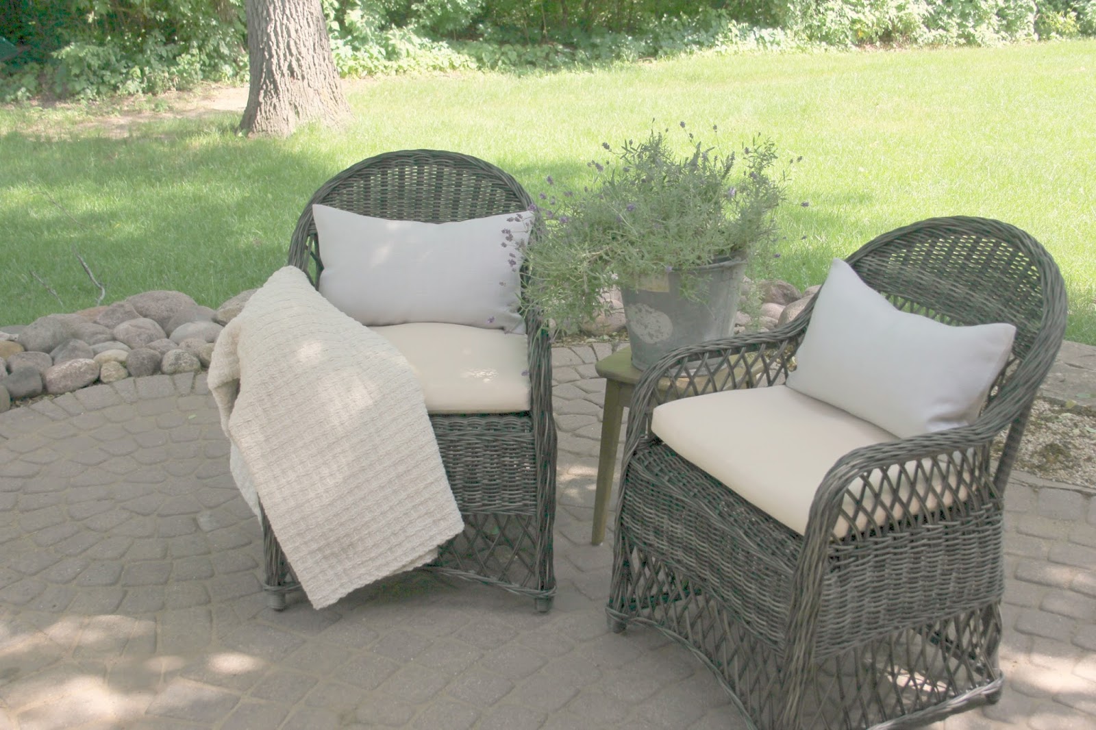 Rattan chairs on patio with RH pillows - Hello Lovely Studio. Come see renovation photos in Before & After: My Home Renovation.