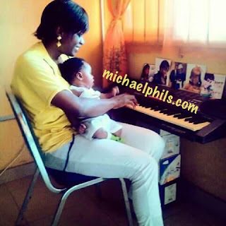 mother playing the solfa notaion of standing on the promises of christ on piano