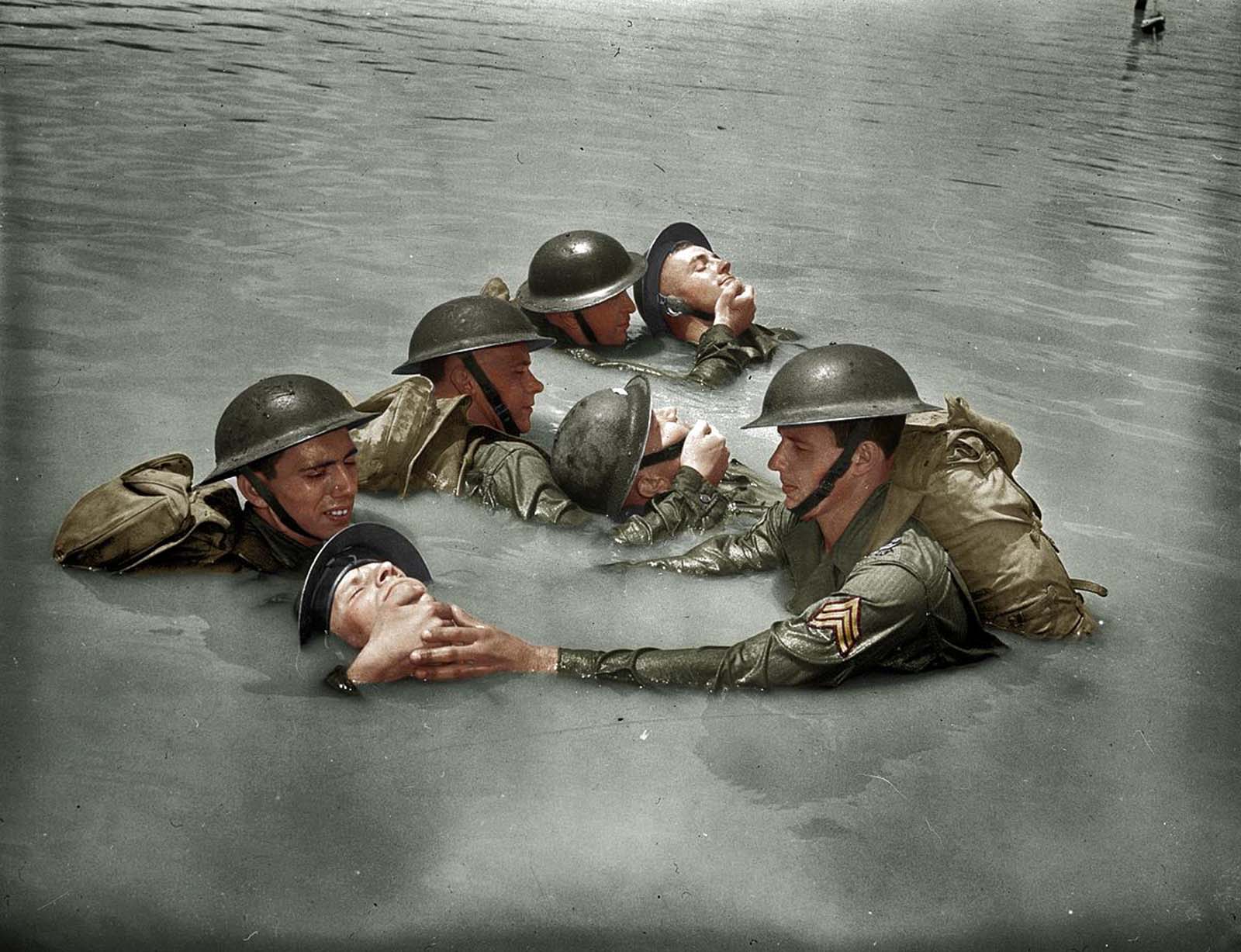 US soldiers in full field equipment learning the chinpull method of saving men from drowning 1942 - 7