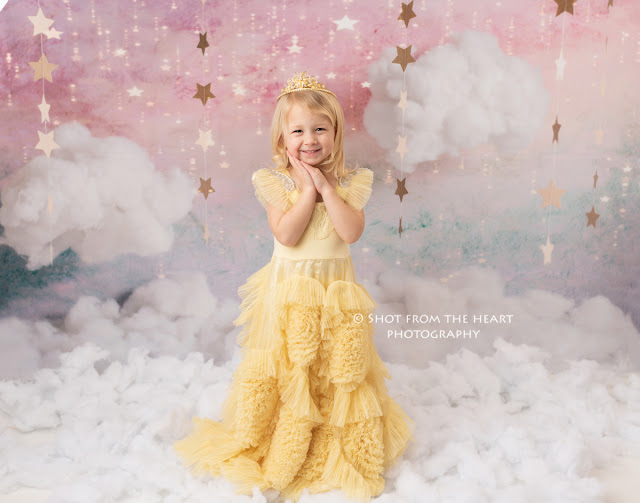 girl in yellow doll cake dress with clouds and sparkly background
