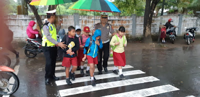 Pelayanan Prima, Kasat Lantas Polres Melawi Bersama Anggotanya Lakukan Ojek Payung