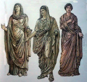 Calíope a la derecha [musa de la poesía] y Sibila a la izquierda [una de las diez profetisas] En el centro un varón. Las figuras femeninas usan la Palla y el hombre una toga.