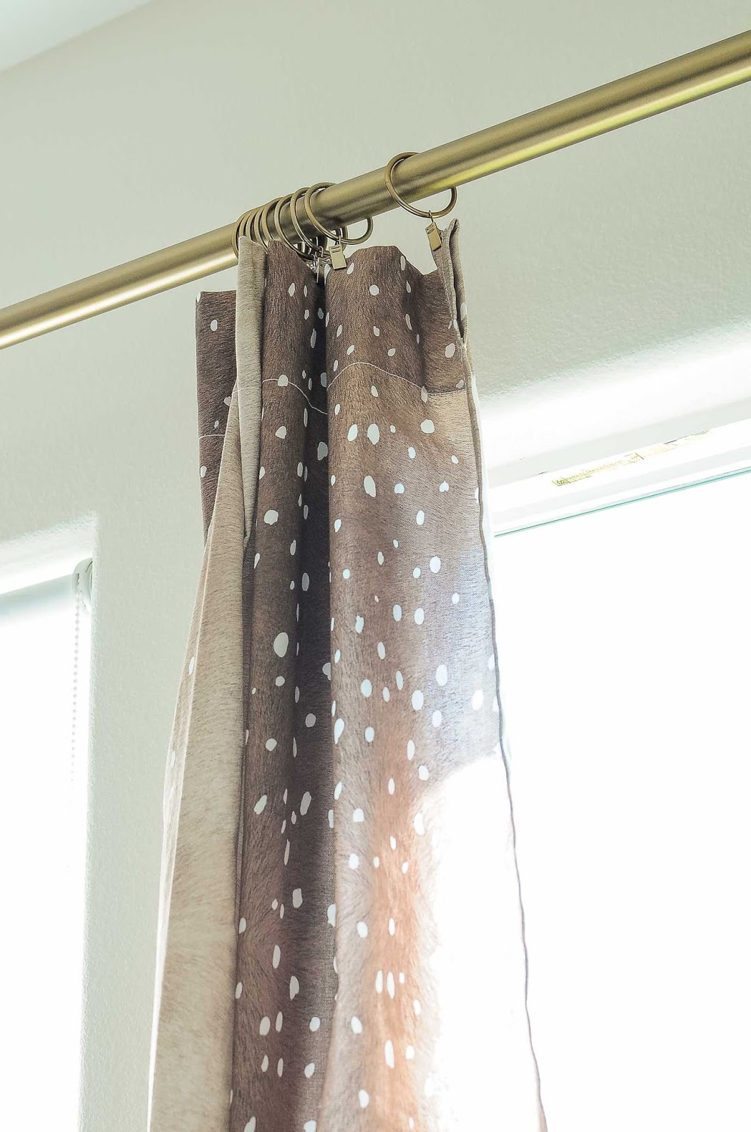 Fawn or antelope drapery/curtain panels look chic when hung from a warm gold brass curtain rod.