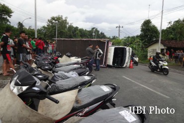 Single accident occurred again in the national road Jogja-Wates, Sukoreno Village area, District Sentolo, Kulonprogro. A truck carrying 21 units of motorcycles rolled up to cover the half of the road, Friday (01/13/2017) afternoon.  The incident began when a truck plate number AD 1326 PJ drove from Jombor Sleman towards Wates. When arrived at Jalan Jogja-Wates kilometer 20, the driver lost control because of the steering lock so that rolled round the corner. As a result, the motorcycle that transported the truck crashed and scattered on the road. The incident invited the attention of local residents and road users. Many of those who came to the scene to watch the condition of the truck. "I am again in the shop and then there was a loud noise in the street. It turns out there was a truck overturned. I see there is one motorcycle that were piled in the streets. I think there is a rider was hit by a truck but it turned out that charge, "said Tini, a shop owner near the scene. The truck driver named Sarjiman claimed sudden steering lock and can not be moved. He tried to put the brakes on the vehicle but did not succeed. Truck kept going and hit a road divider in the corner. He then chose to swerve to the left so that the truck does not jump over the divider so that the truck overturned. Sarjiman was lucky not to be injured. Traffic flow is also in quiet conditions so that there is no other road users are hurt. "The road runs out of rain. I melaku speed of 60 kilometers per hour. I do not know why suddenly ngancing the wheel, "said Sarjiman. daily source jogja
