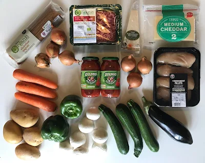 a flat lay of products received in exchange for the post including: chicken breast fillets, cheddar, parmiagiano, beef mince, spaghetti, onions, carrots, potatoes, peppers, mushrooms, courgettes and an aubergine