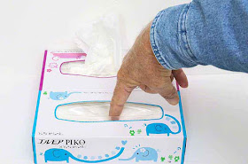 Poking a finger into center of tissue box