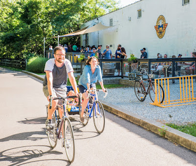 Photo of cyclists passing Yellow Springs Brewery on the Little Miami Scenic Trail.