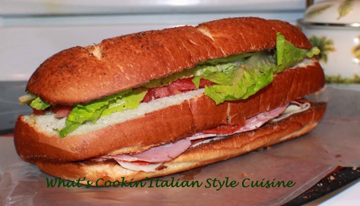 This is a salad in a large loaf of sliced bread in 3 layers called Antipasto Submarine Salad Sandwich. antipasto is an Italian salad with imported meats and cheese with lettuce, tomato and Italian Dressing 