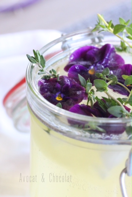 alt="limonade sureau dans un pot en verre, décorée de pensées violettes et de thym frais"