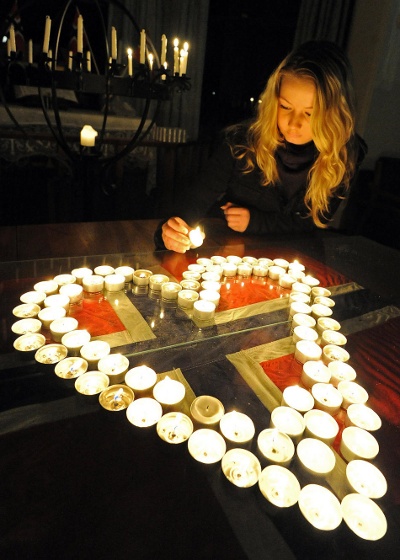 Caria Naess ved en mindehøjtidelighed i Sydney, med hjerte af fyrfadslys arrangeret over Norsk flag