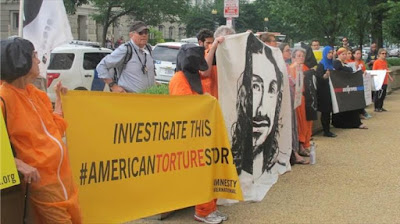 Estadounidenses frente al Departamento de Justicia, llevando pancartas en las que piden la investigación sobre torturas de la CIA. 27 de junio de 2015