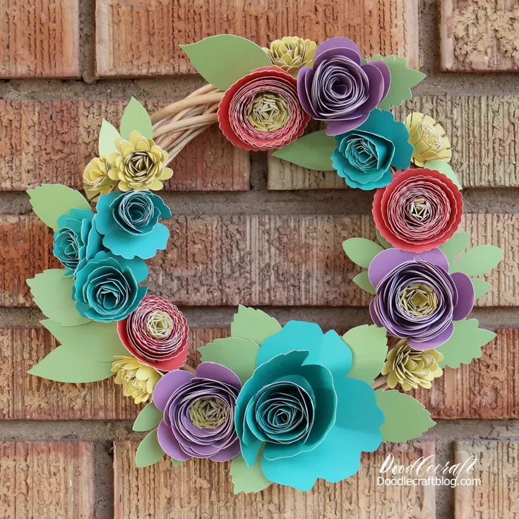 Make flowers with brightly colored paper rolled into 3D flowers and hot glued onto a wreath form.