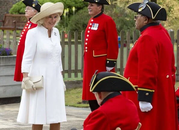 The Duchess of Cornwall wore a white embroidered coat dress with beige leather shoes, and beige hat and she carried beige clutch