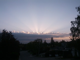 Sun rays scattered above the clouds at dawn.