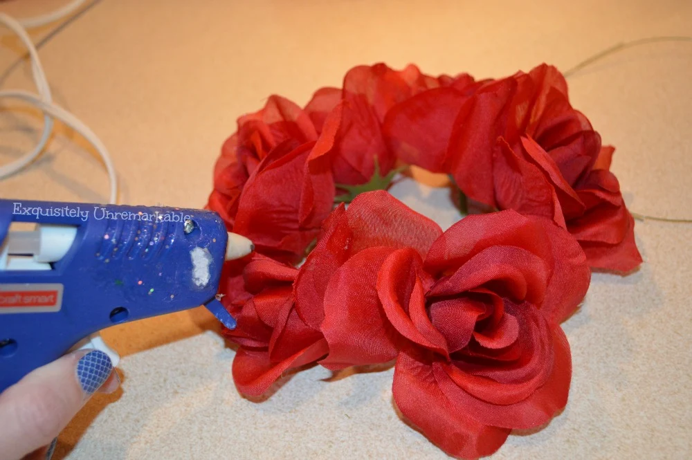 Dollar Store Floral Candle Rings in a circle with a glue gun