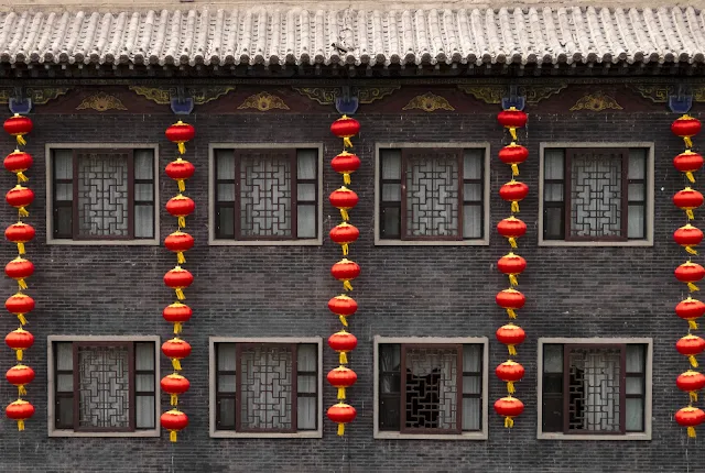 Red lanterns on a grey brick building in Pingyao, China