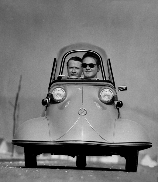 Front shot of two men riding in the three wheeled German made Messerschmidt. 1954