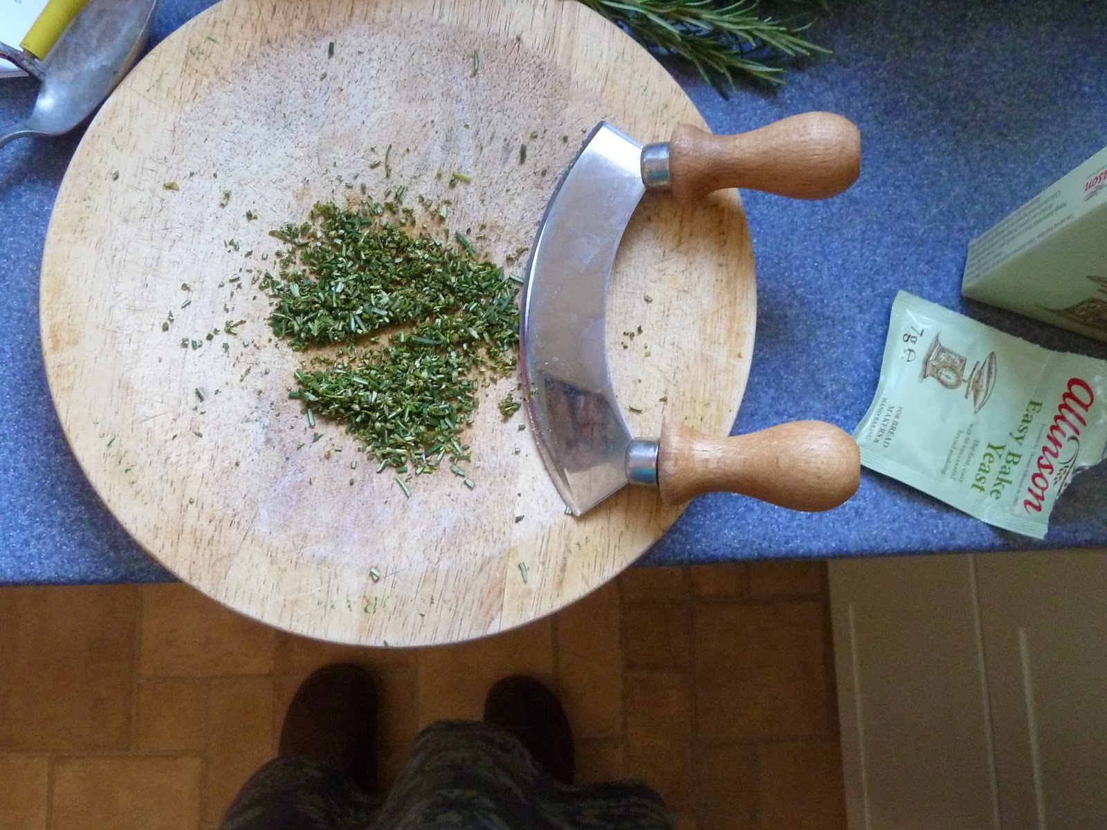 Freshly chopped rosemary on board with rocking knife