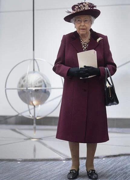 Queen Elizabeth II visited the headquarters of MI5 at Thames House in London. burgundy coat, gold brooch, floral dress