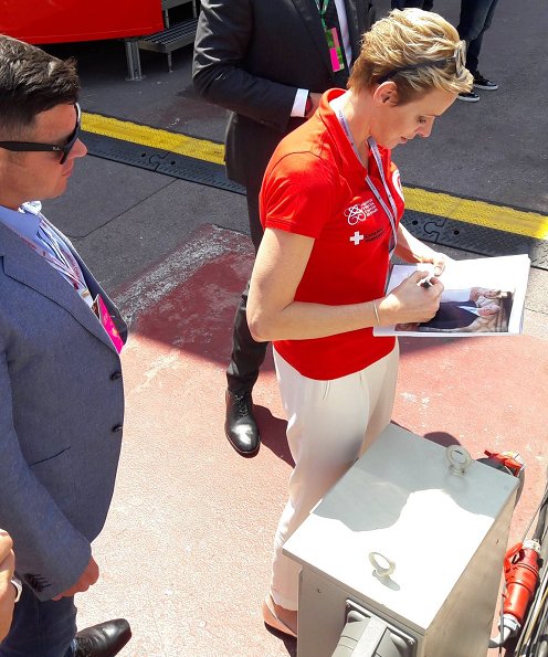 Prince Albert and Princess Charlene at Formula 1 Grand Prix. Princess Charlene wearing the T Shirt of the red cross of Monaco