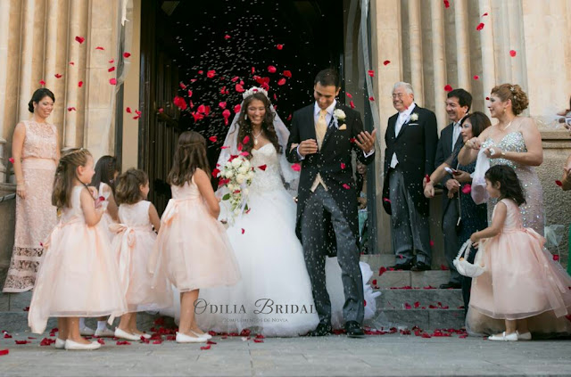 Novios saliendo de la iglesia con arroz y petalos de rosa - ideas blog Odilia Bridal