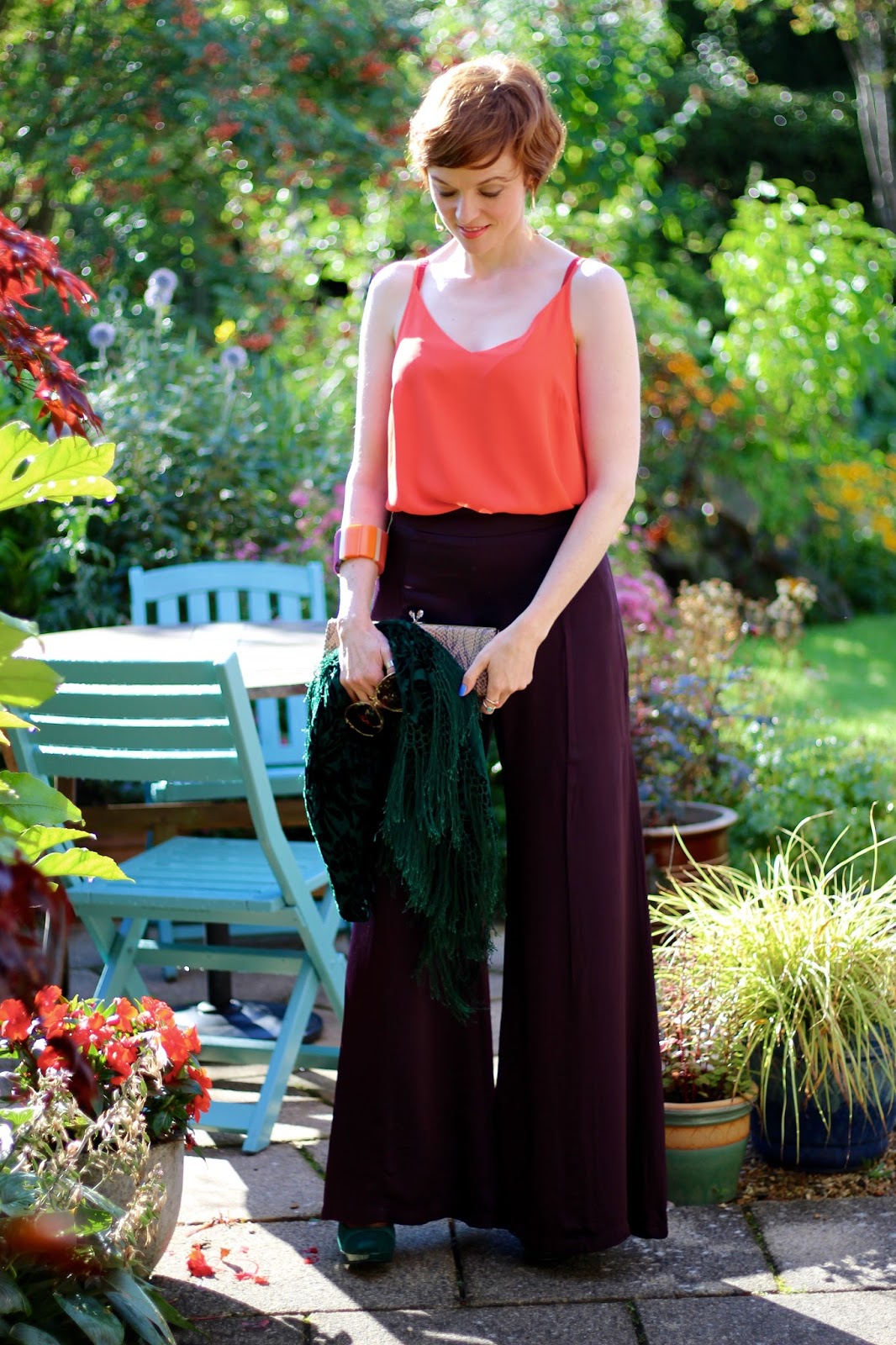 Fake Fabulous | Aubergine satin wide legged trousers, orange camisole, green velvet shawl and heels, nude clutch, over 40.