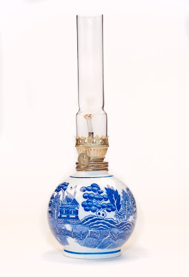 A small Blue Willow oil lamp with round base and tall narrow chimney.