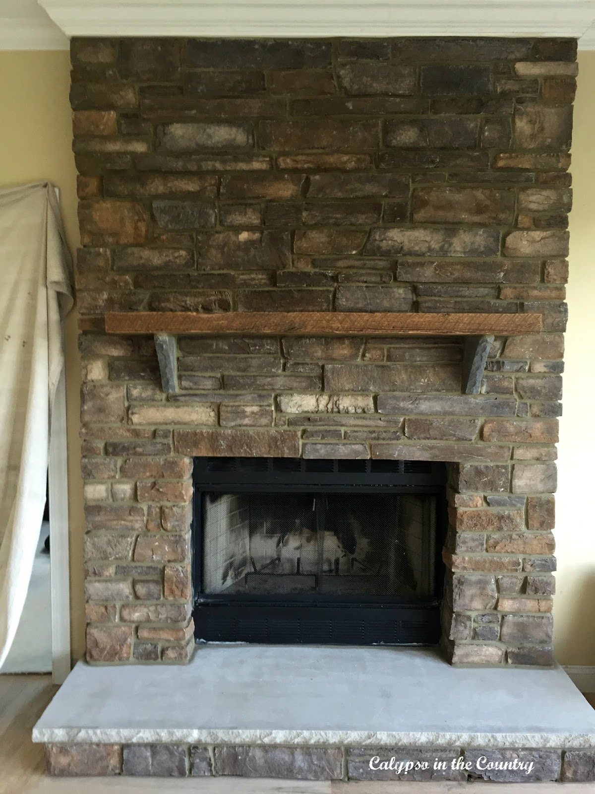 Before and After stone fireplace with rustic mantel - final reveal