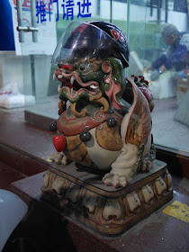 helmet with plastic vizor on top of a Chinese guardian lion