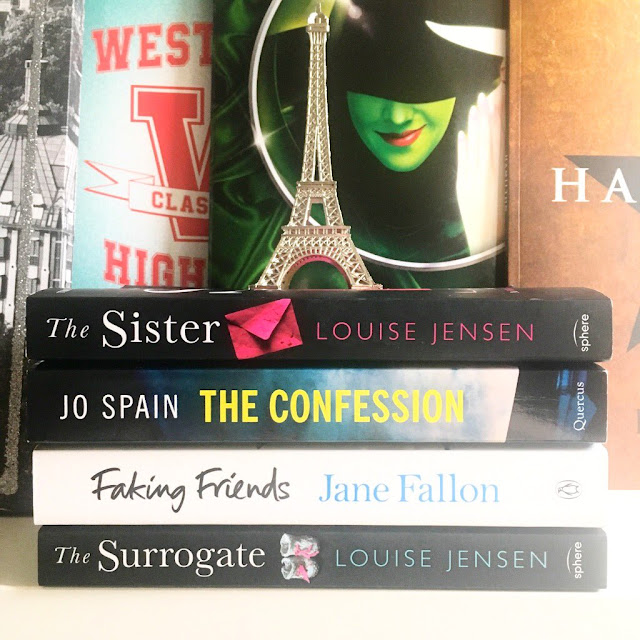 stack of books in front of musical programs with eiffel tower ornament on top. The Surrogate, Faking Friends, The Confession, The Sister