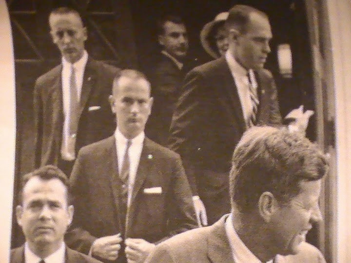 Agent Ken Wiesman (bottom left), Ned Hall II (buttoning suit), Ernie Olsson (top, left) etc.
