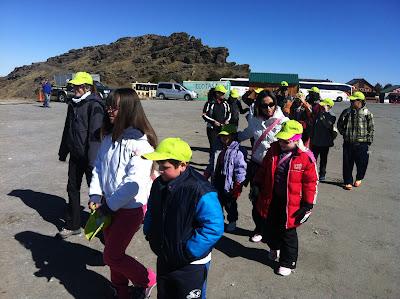 La imagen muestra a todos los alumnos y profesores con las gorras de la ONCE y andando hacia la zona de trineos.
