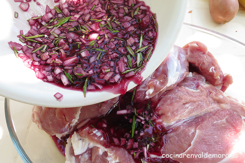 Echando la marinada sobre la pierna de cordero