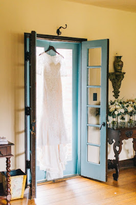 wedding dress hanging in doorway