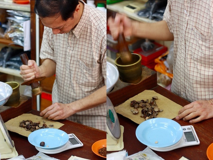 pounding nutmeg for traditional chinese medicine and for burning as incense for a prayer offering
