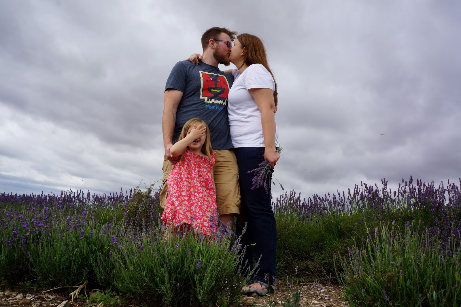 Parents kissing and a child face-palming