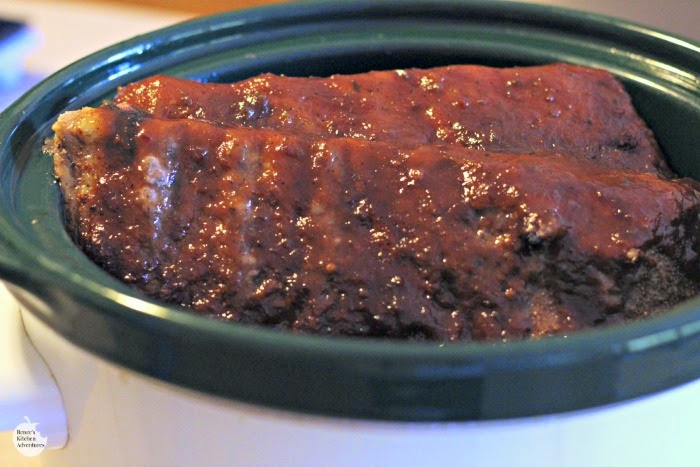Fall-Off-The-Bone Slow Cooker Ribs by Renee's Kitchen Adventures in the crock of a slow cooker, basted with BBQ sauce