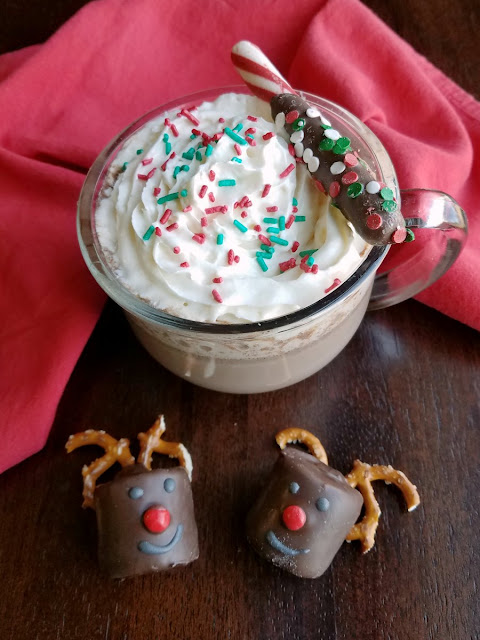 Come in from playing in the snow to a hot mug of rich, creamy and delicious hot chocolate. Making it in the slow cooker means it's super simple and hot and ready when you are. mug of hot cocoa with 2 reindeer decorated marshmallows