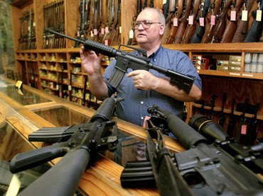 man holding up gun in gunshop in America