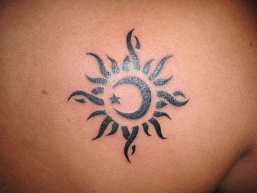 Este preto tatuagem mostra uma lua crescente encapsulado em um sol e é retratado em um estilo tribal.