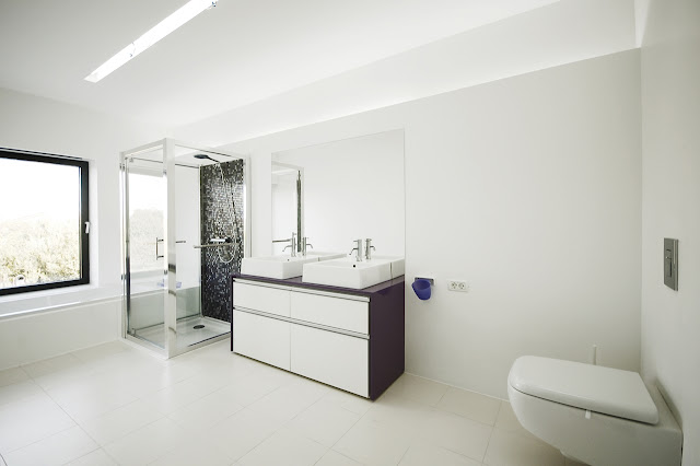 Modern white bathroom in the Black On White House by Parasite Studio 