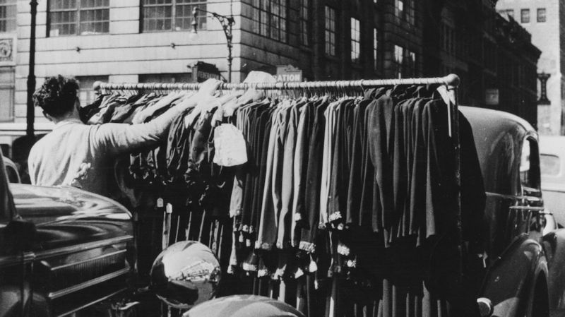 Pushing a rack of clothing through the garment district around 1950.
