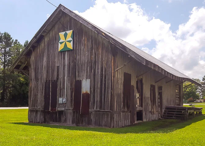 Colorful barn quilt on old building