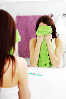 Приложил полотенце. Девушка вытирает лицо полотенцем. Девушка в зеленом полотенце. Вытираться полотенцем. Лицо закрыто полотенцем.