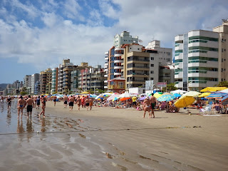 Playa de Itapema con sombrillas y gente disfrutando el día soleado