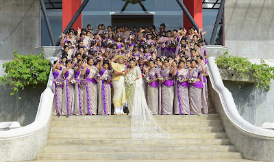 Sri Lankan wedding couple Nisansala and Nalin pose for photographers alongside their wedding party during their Guinness World Record-breaking wedding in Negombo, some 30kms north of Colombo, on November 8, 2013. Including 126 bridesmaids, 25 best men, 20 page boys and 23 flower girls the wedding breaks the previous record, held by a wedding in Bangkok that included 96 bridesmaids.