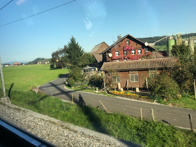 スイス鉄道の車窓から見たスイスの風景　窓辺に花が飾ってあってカワイイ