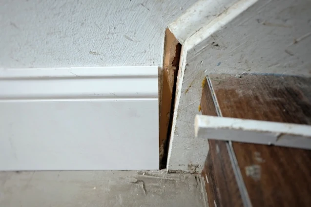 reinstalling baseboard at the bottom of the stair